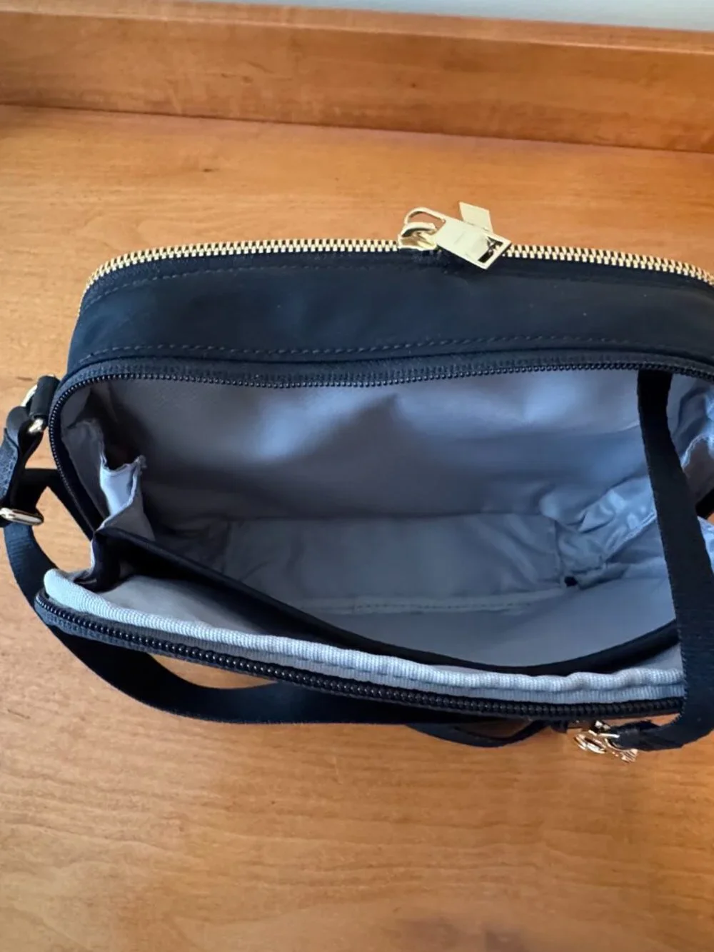 Authentic TUMI Voyageur Langley Crossbody in black with gold-tone hardware